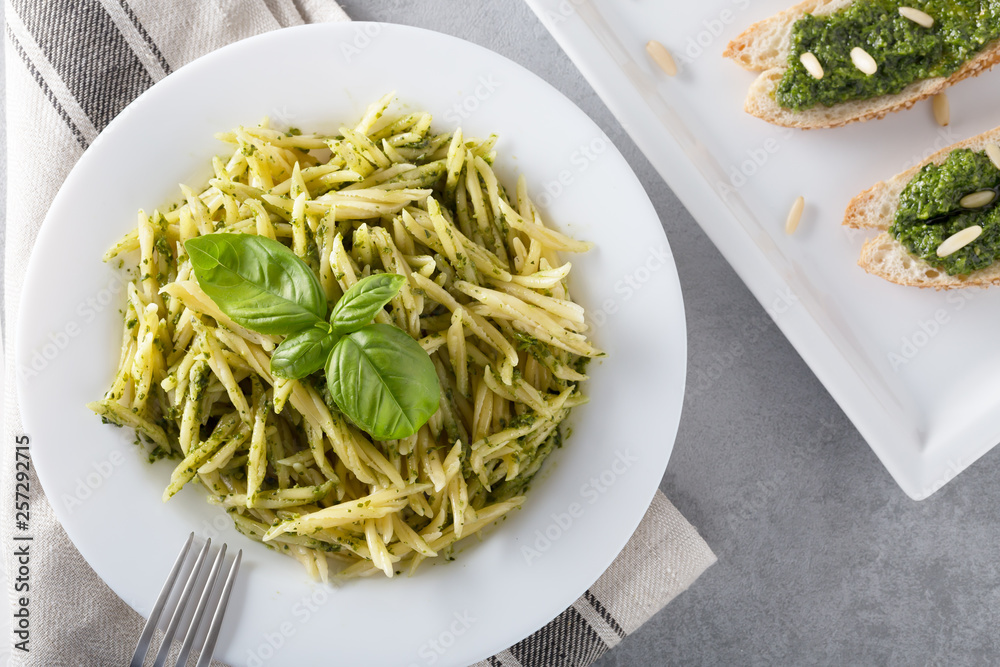 Traditional trofie pasta with pesto sauce on white plate