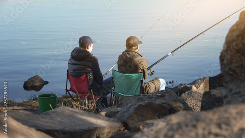 Two friends fishing to escape stressed city life, common interests, free time