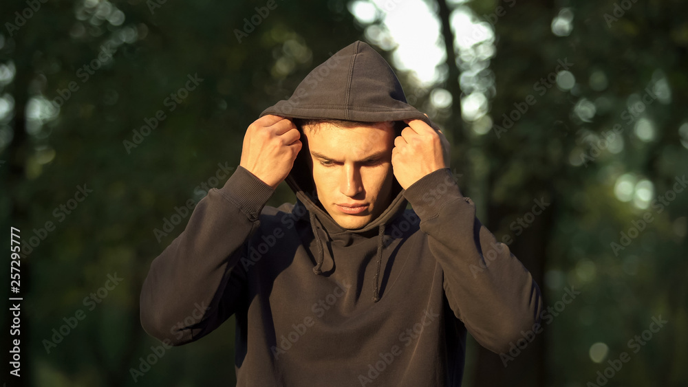 Male taking off hood, making decision to give up addiction, rehabilitation Male taking off hood, making decision to give up addiction, rehabilitation
