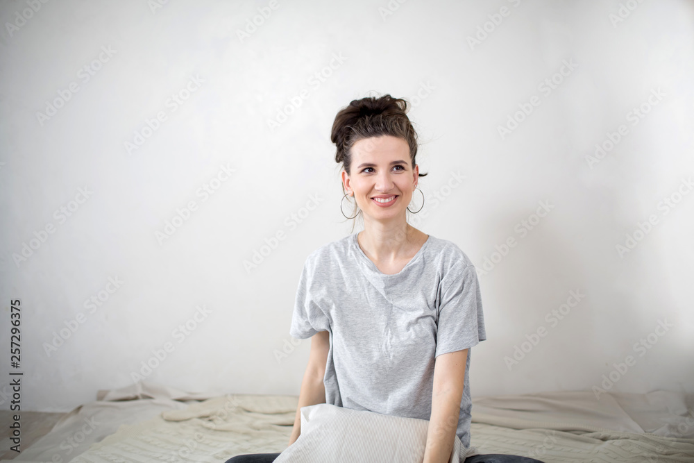 Young happy girl in the bedroom. White background. Young happy girl in the bedroom. White background.