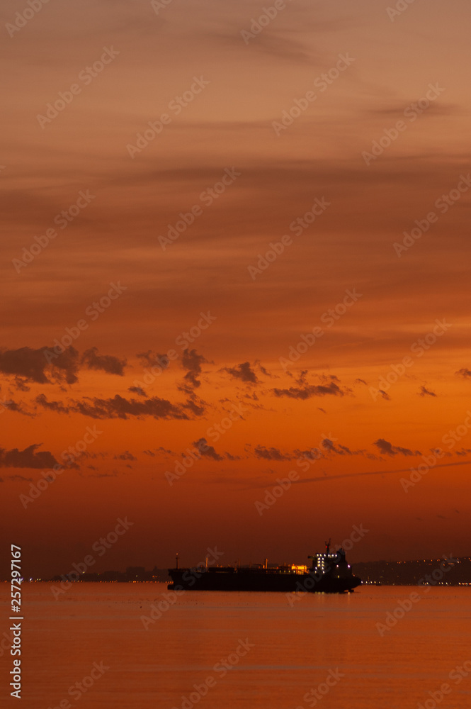 Cargo container ship at mediterranean coast in sunset