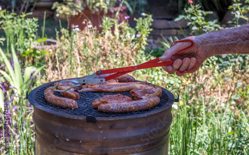 Red meat being grilled on the coals of an open fire in an outdoor setting image with copy space in landscape format