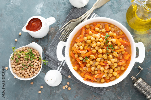 Chana Masala, spicy chickpea curry with carrot and onion in tomato sauce. Vegetarian dish for lunch. Indian cuisine