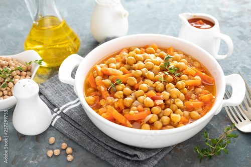 Chana Masala, spicy chickpea curry with carrot and onion in tomato sauce. Vegetarian dish for lunch. Indian cuisine