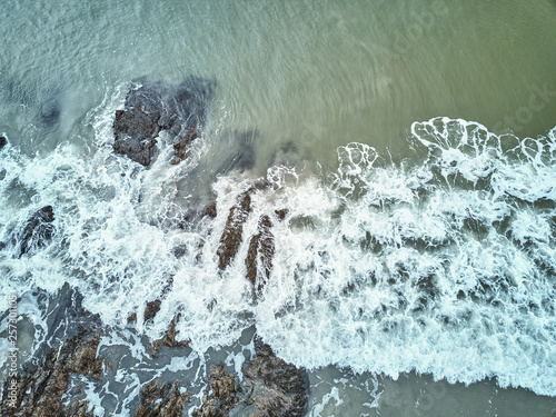 Aerial drone image of a rocky beach on the Maine coast with the waves washing up on the rocks