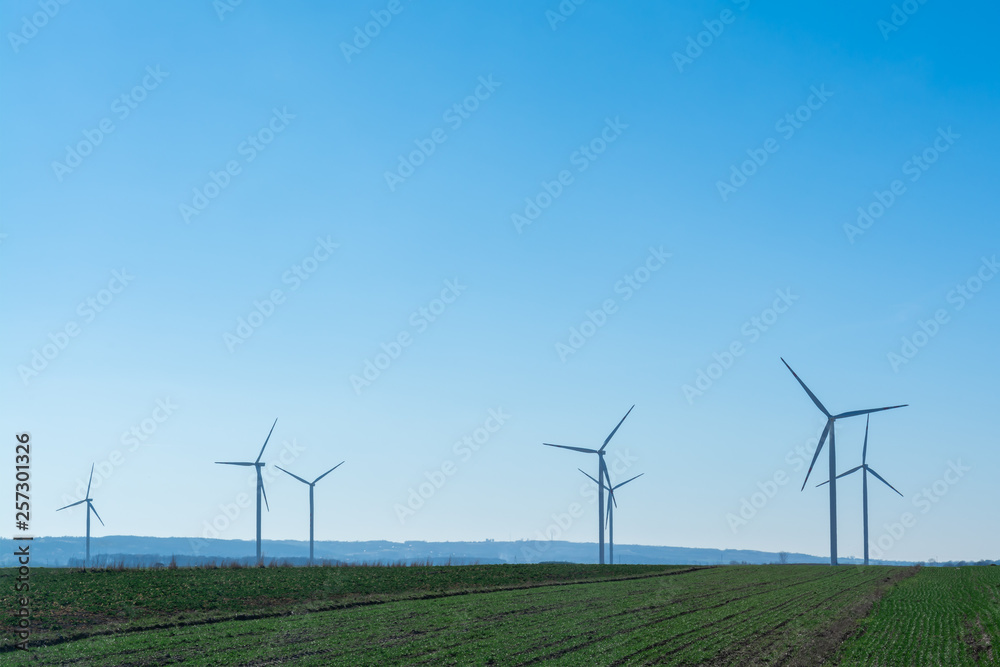 Field with windmills for electric power. Clean energy produced by the wind. Extraction of energy from the air Field with windmills for electric power. Clean energy produced by the wind. Extraction of energy from the air
