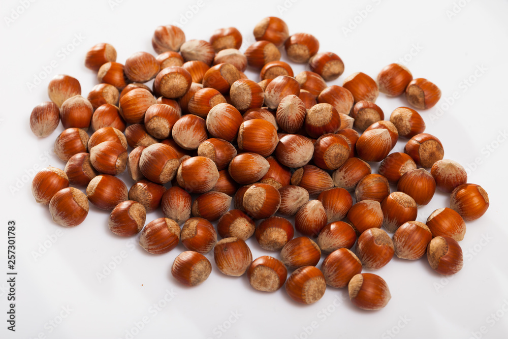 Obraz premium Unpeeled hazelnut on white surface closeup