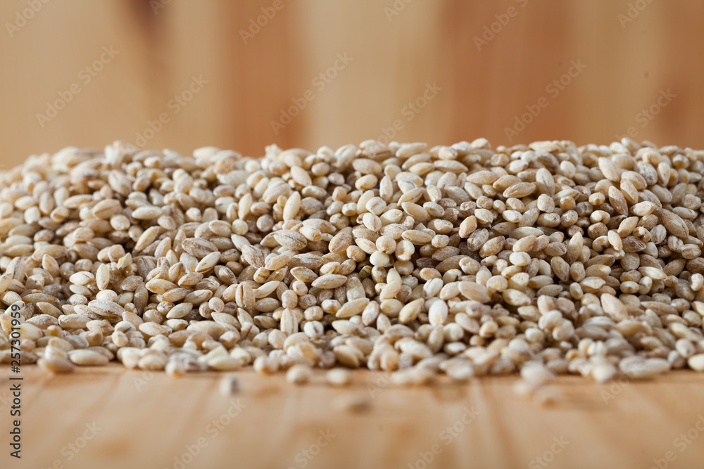 Obraz premium Pearl barley on a wooden surface, macro