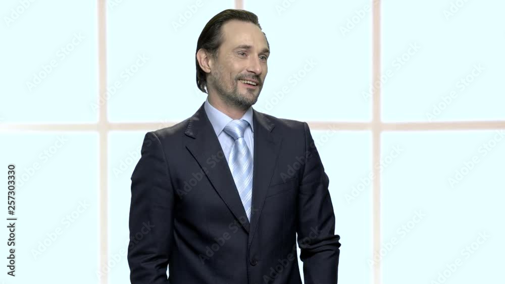 Handsome mature businessman with seductive look. Stylish self-assured macho-man unbuttoning his black suit jacket. Checkered window background. Handsome mature businessman with seductive look. Stylish self-assured macho-man unbuttoning his black suit jacket. Checkered window background.