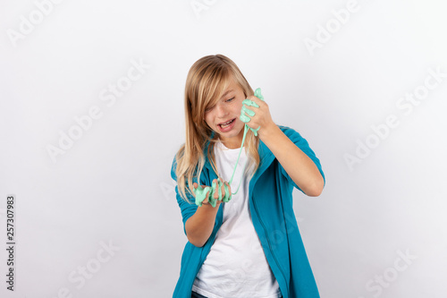 Cute girl playing with green slime looks like gunk