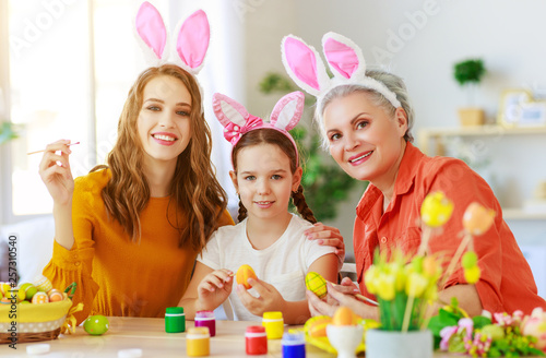 happy Easter! family grandmother, mother and child paint eggs and prepare for holiday.
