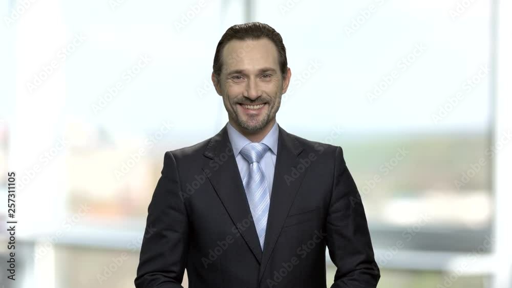 Handsome businessman with beard looking at camera. Portrait of smiling mature entrepreneur dressed in suit. Blurred window background. Handsome businessman with beard looking at camera. Portrait of smiling mature entrepreneur dressed in suit. Blurred window background.