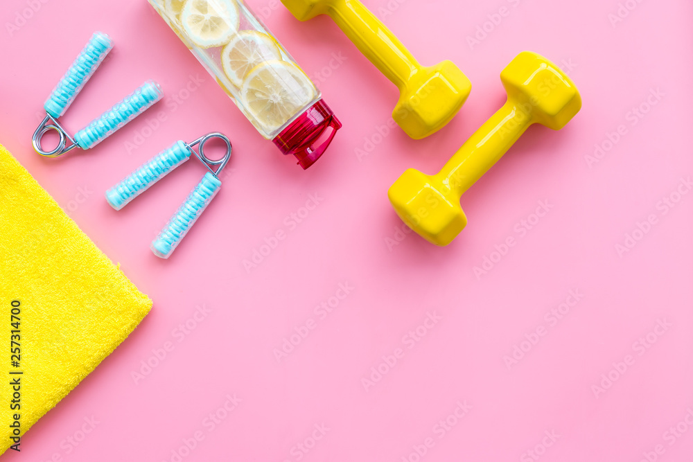 workout with bars, bottle of water and wrist builder pink background top view mockup