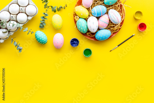 eggs with colorful paint for easter tradition on yellow background top view mockup
