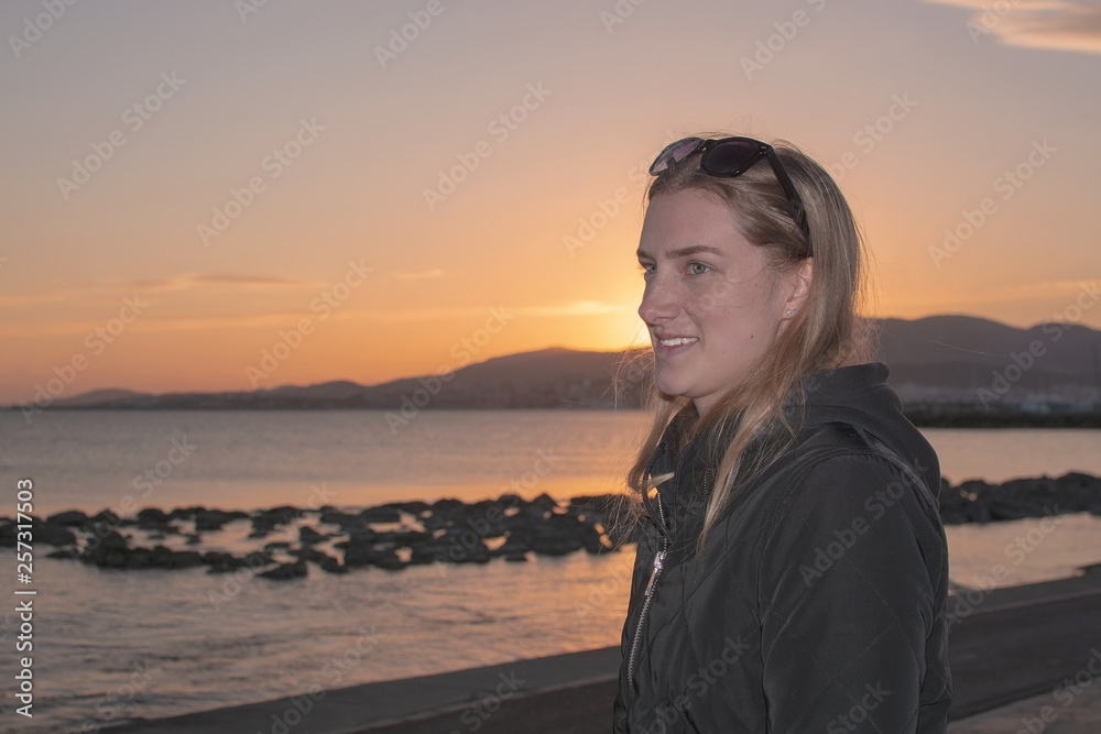 Fototapeta premium Young beautiful woman with classical natural look in profile at sunset
