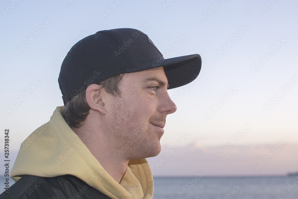 Profile shot of handsome smiling natural and casual looking male in late twenties