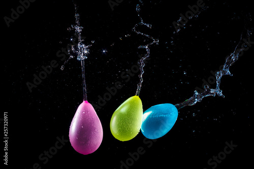 Amazing explosion big water color balloon bomb with splash  water on isolated  black background with flash. Сoncept of freezing moment of time.