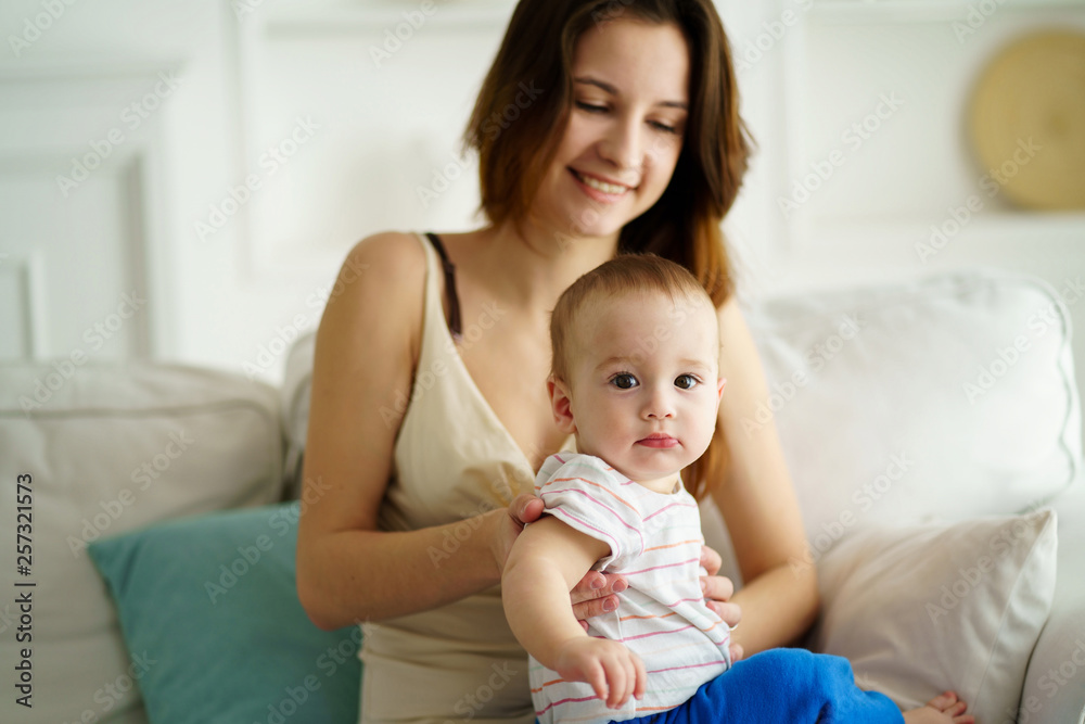 Mother playing with baby boy in living room. Happy parent and son having fun indoor. Cheerful sweet kid portrait, mom and child. 