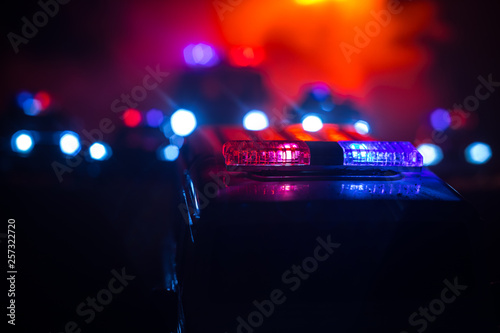 Police cars at night. Police car chasing a car at night with fog background. 911 Emergency response pSelective focus photo