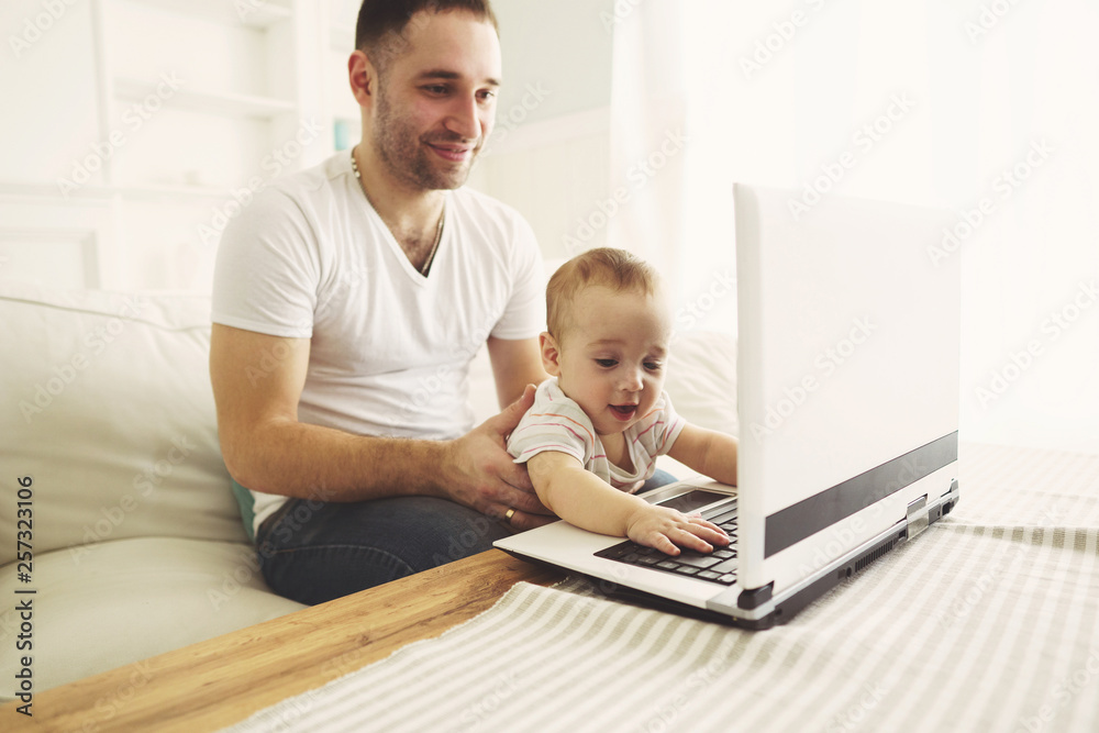 Happy family using laptop and having fun. Father and son watching video or playing game together. Parenting, childhood, technology and people concept Happy family using laptop and having fun. Father and son watching video or playing game together. Parenting, childhood, technology and people concept