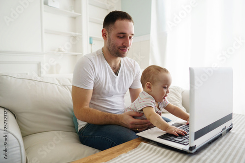 Happy family using laptop and having fun. Father and son watching video or playing game together. Parenting, childhood, technology and people concept © Vadym