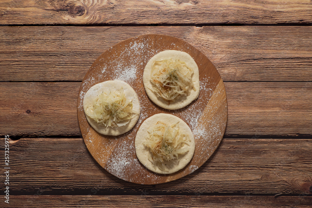 Fototapeta premium Cooking pies with cabbage. Rustic cuisine. 