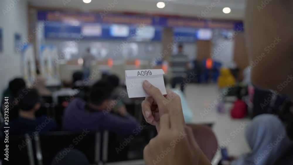 close up of the queue number from a customers hand while waiting for a long time in public services