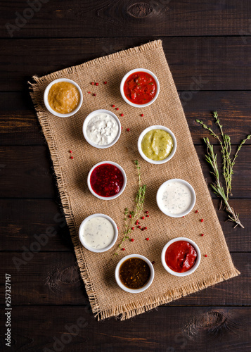 Set of various sauces on a dark rustic background.