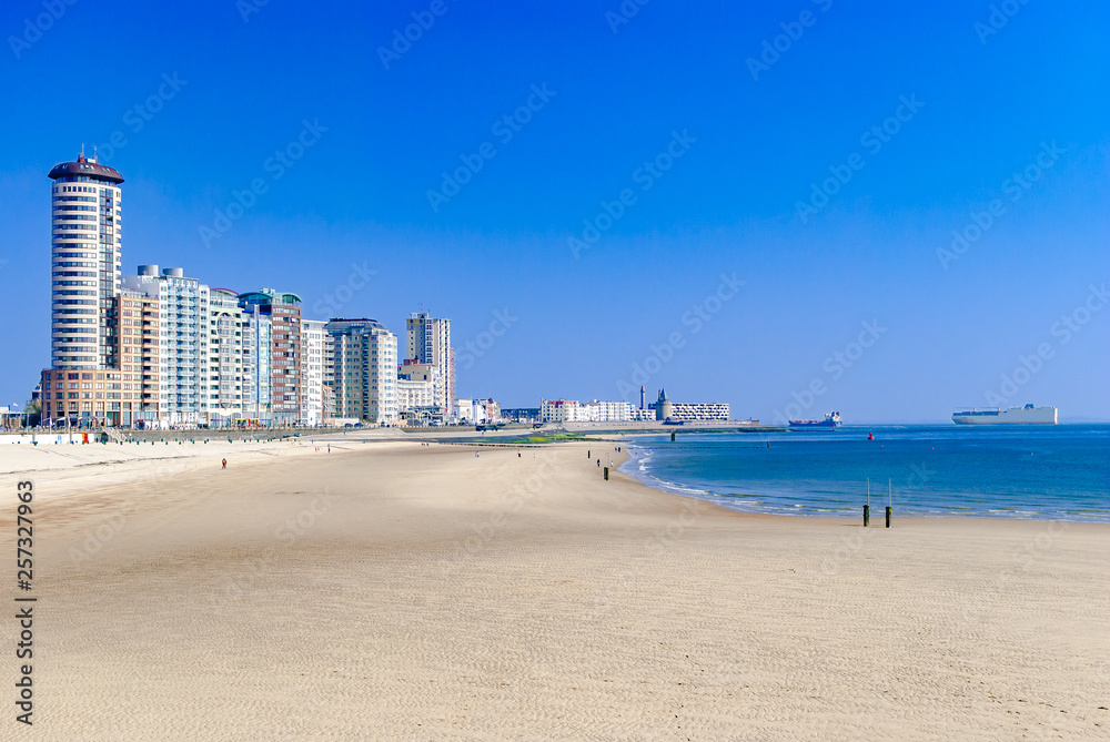 View of a modern coastal city or town and its beach. Big cargo ships in the sea. Summer concept. Vacation. Travelling. Vlissingen, the Netherlands. Northern sea.