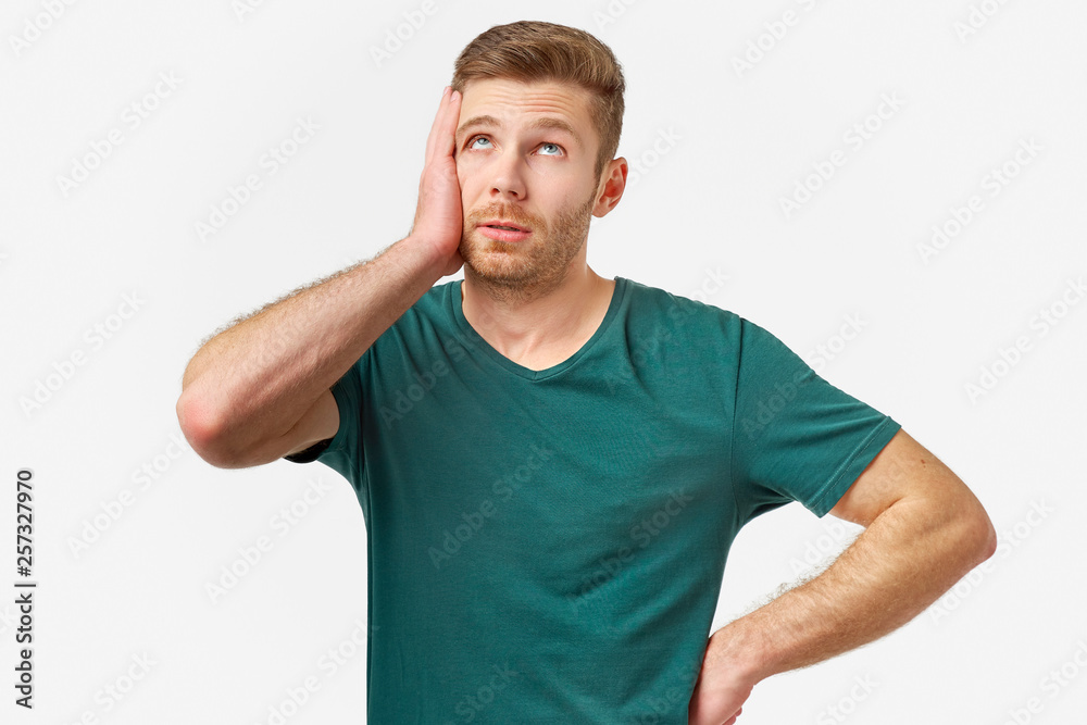 Studio portrait of a young man. He puts hand to face in shame and frustration. The concept of failure and facepalm Studio portrait of a young man. He puts hand to face in shame and frustration. The concept of failure and facepalm