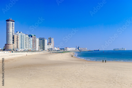 View of a modern coastal city or town and its beach. Big cargo ships in the sea. Summer concept. Vacation. Travelling. Vlissingen, the Netherlands. Northern sea. © Ovchar Anastasya