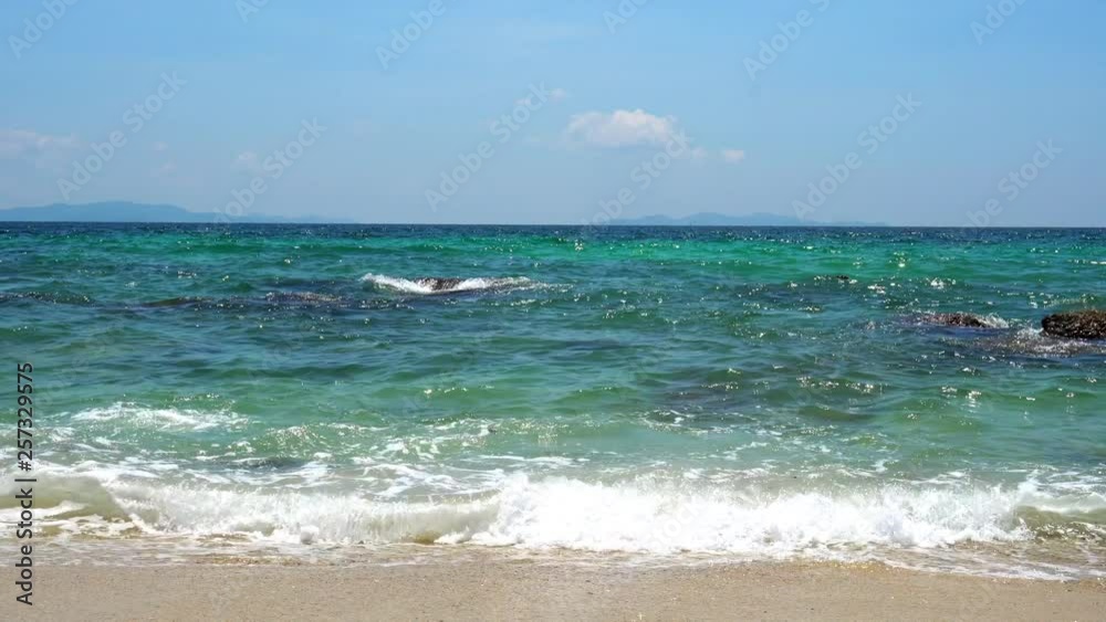 4K WS Landscape Selective focus the sun glimmering flares peaking the green sea surface and sea water wave splashing against the rocks on the tropical sand beach with sky and clouds backgrounds 4K WS Landscape Selective focus the sun glimmering flares peaking the green sea surface and sea water wave splashing against the rocks on the tropical sand beach with sky and clouds backgrounds