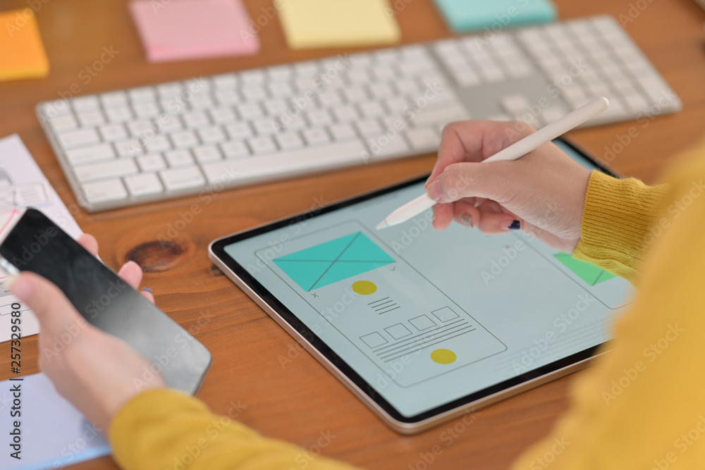 Fototapeta premium UI designer with tablet designing framework for mobile phone.