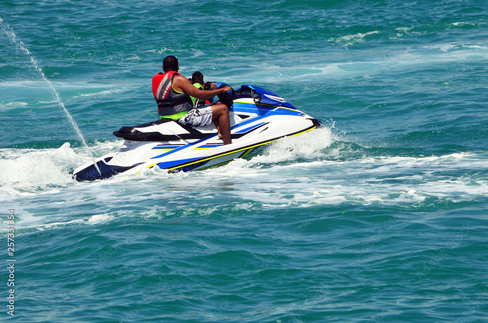 Father and his toddler son riding a jet ski on the Florida Intra-Coastal Waterway off Miami Beach