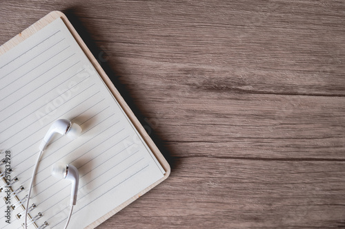 Earphone on empty boon on wooden table, copy space, for presentation and banner website