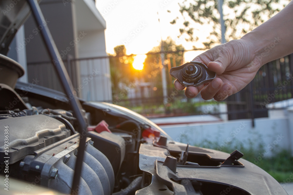 Mechanic man checking car engine radiator cooling tank water level