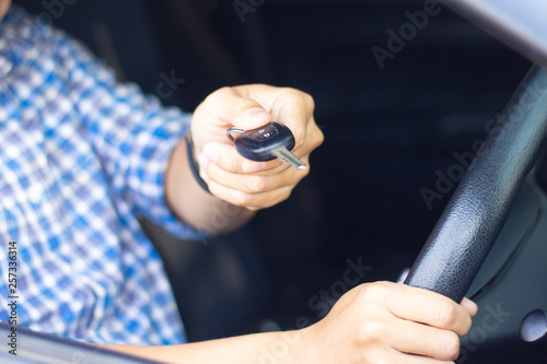 Man sitting in car and showing car key to dealer. Auto business, car sale, car rental consumerism business, people transport automobile service or car insurance concept.