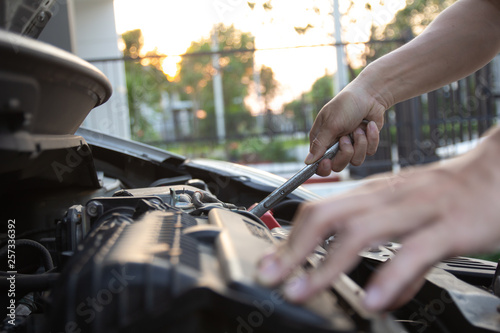 Mechanic, technician man holding spanner checking car engine. car service, repair, fixing, checking maintenance working at auto repair garage workshop. inspection vehicle concept.