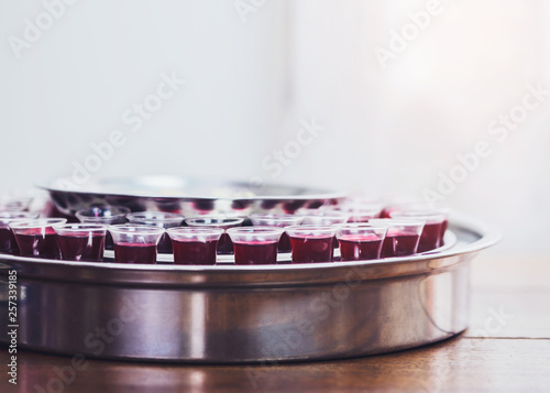 Close-up of a wine glasses  in communion  tray on wooden table with window light, christian background with copy space