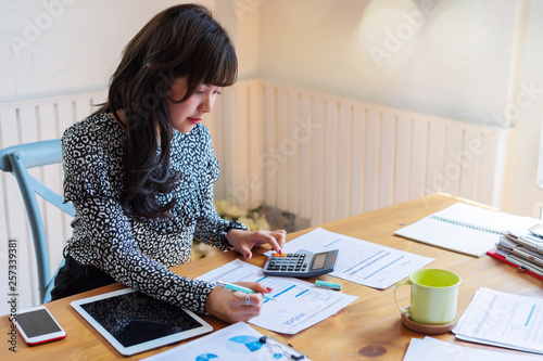 Happy beautiful asian accountant woman working about financial with business report and calculator.financial or accounting concept.