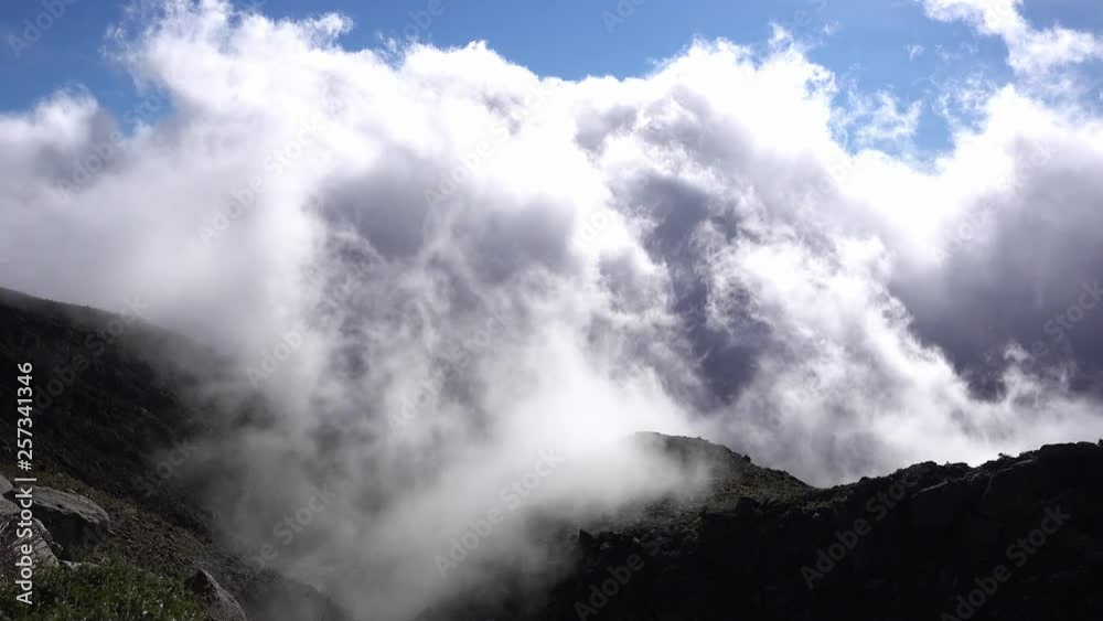 Low flying whispy clouds floating up a rocky surface Low flying whispy clouds floating up a rocky surface
