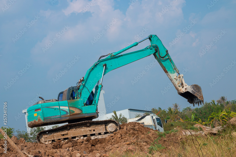 The blue-green excavator is working. The blue-green excavator is working.