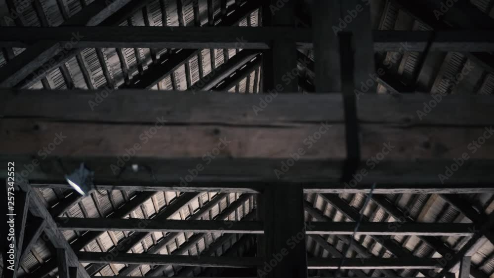 Panned shot upwards with wooden roof beams and ceiling in background. Panned shot upwards with wooden roof beams and ceiling in background.
