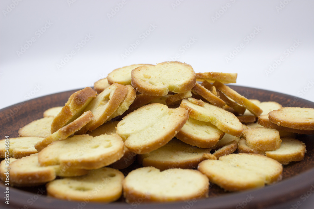 Bake Rolls. The mini bread chips on the brown bowl. Isolated on white background. Bake Rolls. The mini bread chips on the brown bowl. Isolated on white background.