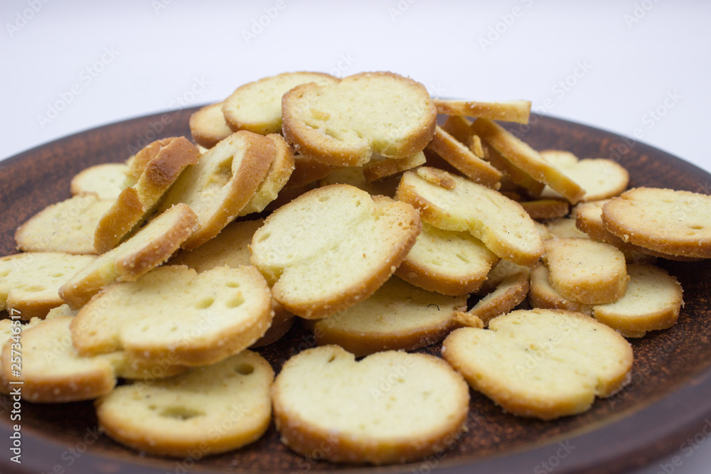 Bake Rolls. The mini bread chips on the brown bowl. Isolated on white background.