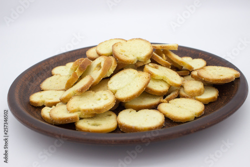 Bake Rolls. The mini bread chips on the brown bowl. Isolated on white background.
