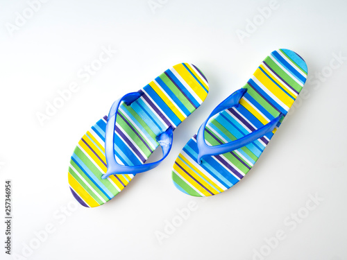 Colorful striped flip flops on white background