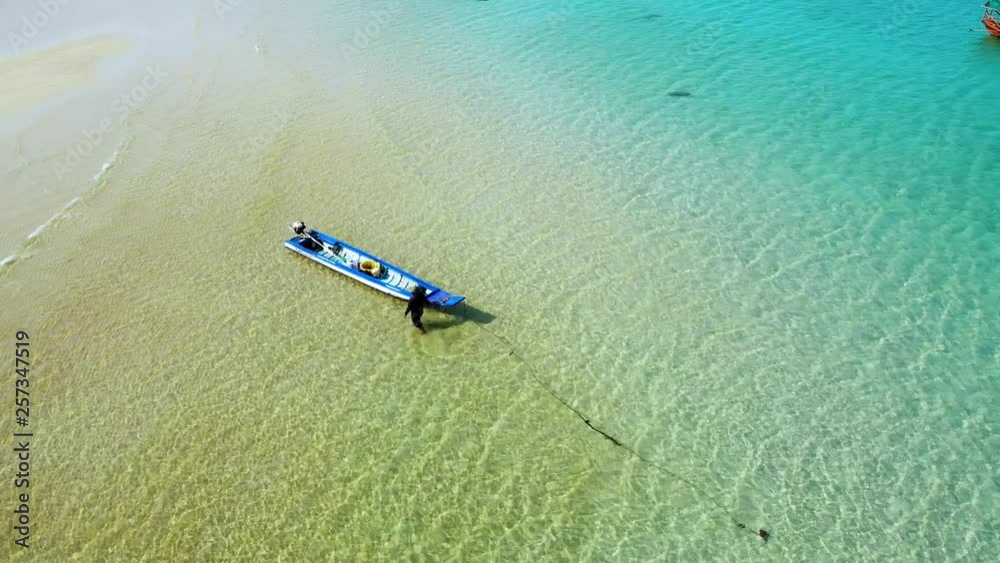 Long tail fisherman boat anchored by tropical beach in Cambodia. Birds eye view. Long tail fisherman boat anchored by tropical beach in Cambodia. Birds eye view.
