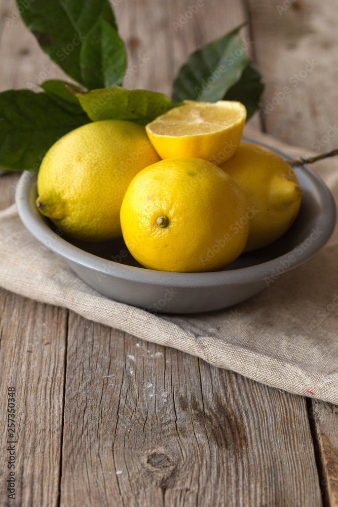 Lemon and half of lemon on brown background. Lemon on brown wooden table