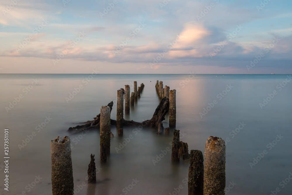 Long exposure shot sunset seascape with mortar of broken bridge. Long exposure shot sunset seascape with mortar of broken bridge.